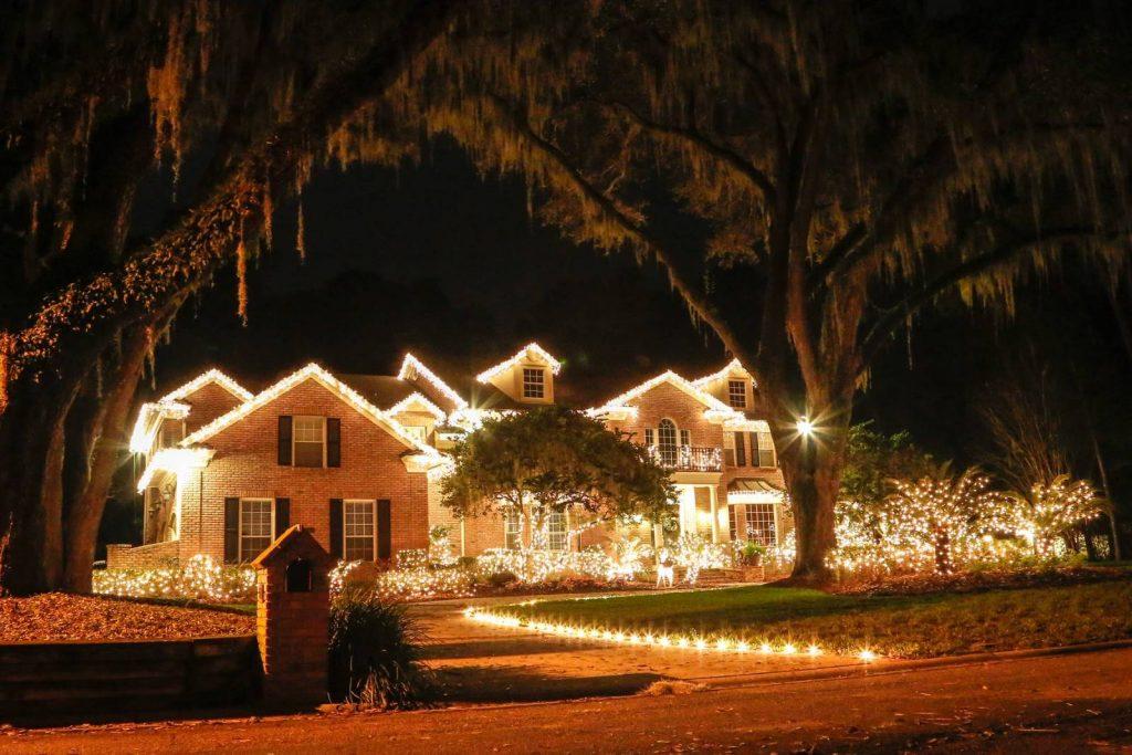 brick house with trees and white Christmas lights